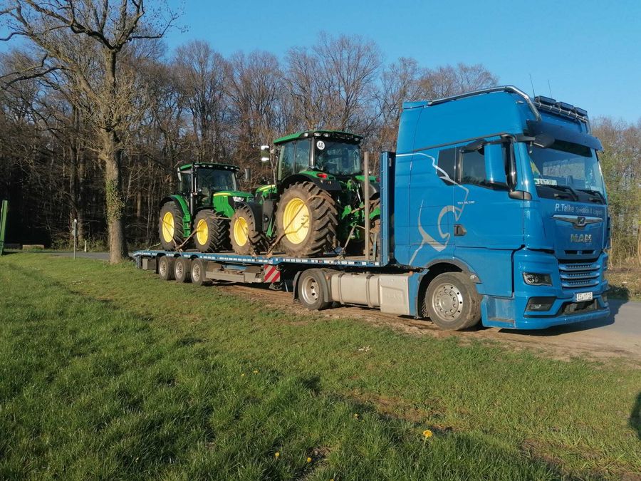 Zwei John Deere Traktoren verladen auf einem Truck zum Transport ins Ausland